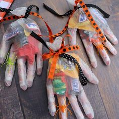 four halloween handprinted hands tied together with orange and black ribbon on top of them