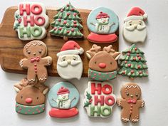 decorated christmas cookies are arranged on a cutting board