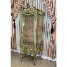 an antique china cabinet in front of a curtained window