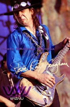 a man in a cowboy hat playing an electric guitar