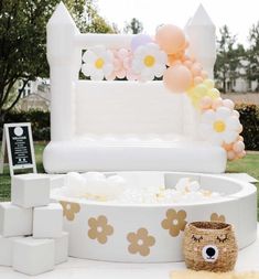 an inflatable bed with flowers and balloons on the top is set up outside