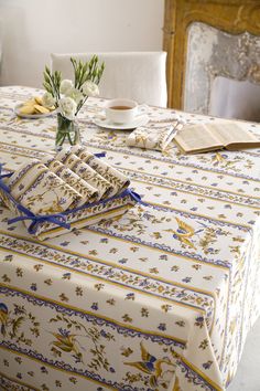 a table topped with two napkins and a vase filled with flowers on top of it