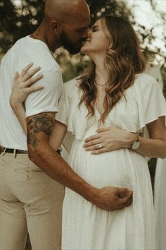 a man and woman kissing while standing next to each other