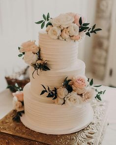 a white wedding cake with flowers on top