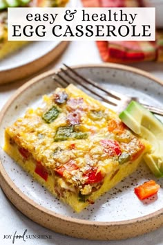 an egg casserole is on a plate with a fork and some sliced vegetables