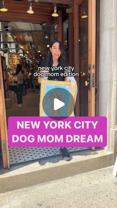 a woman holding a new york city dog mom dream sign in front of a store