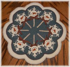 a blue and white snowman placemat on a wooden table