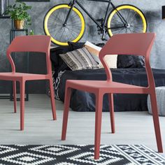 two chairs and a bike in a room with a rug on the floor next to it