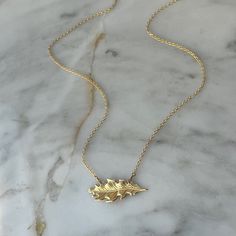 This necklace features a solid brass oak leaf pendant gracefully suspended on a 14k gold fill chain. The oak leaf's timeless design and warm brass hue offer a touch of natural charm. With a clean and minimalist aesthetic, the necklace embraces simplicity, allowing the intricate details of the oak leaf to shine. The 14k gold fill chain adds a hint of elegance, creating a seamless fusion of classic and contemporary style. Durable and versatile, this necklace is a celebration of the enduring beauty found in the simplicity of nature. ● 16" Chain ● 14k Gold fill chain ● Solid Brass Oak Leaf Oak Leaf Necklace, Oak Leaf, Women's Jewelry And Accessories, Leaf Necklace, Leaf Pendant, Minimalist Aesthetic, Gold Filled Chain, Intricate Details, Language English