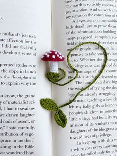 a crocheted mushroom sitting on top of an open book