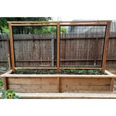 an outdoor garden area with raised wooden planters and fenced in area for plants