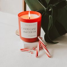 a candy cane and cocoa candle sitting on a table