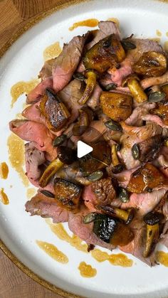 a white plate topped with meat and veggies on top of a wooden table