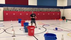 a man standing on top of a basketball court surrounded by buckets