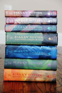 a stack of harry potter books sitting on top of a wooden table