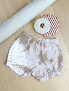 a pair of shorts sitting on top of a wooden floor next to a white object