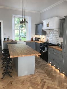 a kitchen with wooden floors and gray cabinets