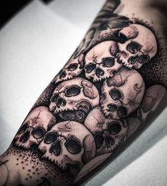 a man's arm with many skulls on it