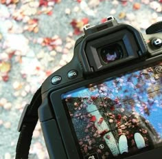 a person holding up a camera with their reflection in the screen and it's lens