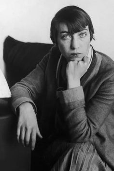 a black and white photo of a man sitting on a couch with his hand under his chin