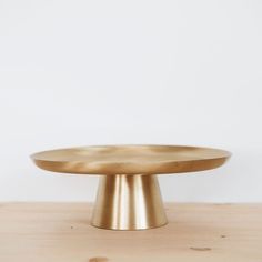 a gold plate sitting on top of a wooden table