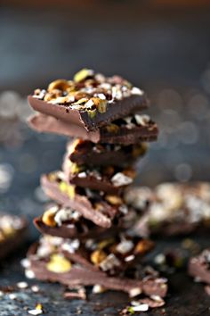 a stack of chocolate pieces with nuts on top