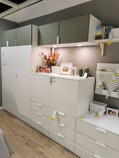 an office space with white cabinets and drawers