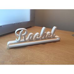 a wooden table with a sign that says rachel on it and the word rachel spelled in white letters