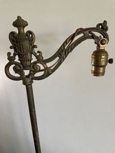 an old fashioned metal lamp with a bell on it's arm and the light is turned off