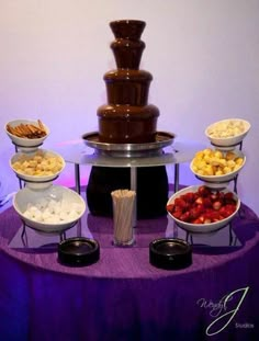 a table topped with lots of different types of desserts and bowls filled with fruit