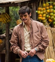 a man standing in front of a fruit stand