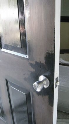 an open door with a metal handle on the front and side doors, painted black