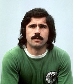 a man in a green shirt with a mustache