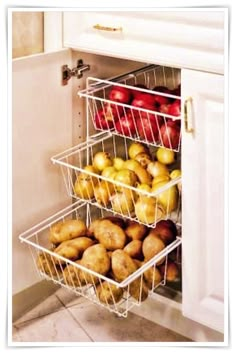 an open refrigerator door with apples and pears in baskets on the bottom shelf next to it