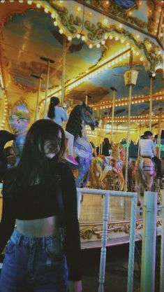 a woman standing in front of a carousel