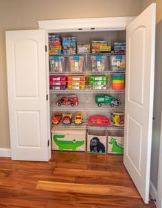 an open closet with toy cars and toys in the bins on the bottom shelf