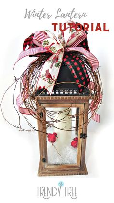 a lantern with a red and white bow on it, sitting next to the words winter lantern