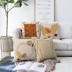 a living room filled with lots of pillows on top of a white couch next to a potted plant