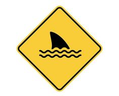 a yellow and black sign with a shark in the water