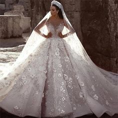 a woman in a wedding dress standing next to a stone wall