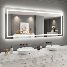 a bathroom with two sinks and a large mirror over it's counter top that is illuminated by lights