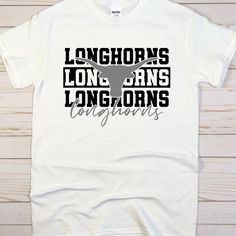 the longhorns t - shirt is white with black and grey letters on it