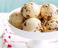 a white bowl filled with ice cream on top of a table next to a red and white towel