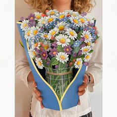 a woman holding a bouquet of flowers in her hands