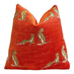 an orange pillow with cheetah and leopards on it