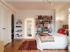 a bedroom with white walls and wooden floors