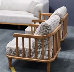 two wooden chairs sitting next to each other on top of a hard wood floor in front of a white couch