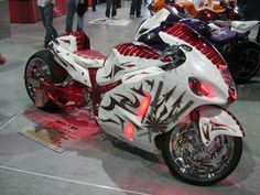 the motorcycle is painted red and white with designs on it