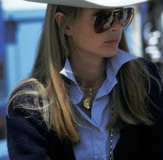 a woman wearing a white cowboy hat and sunglasses