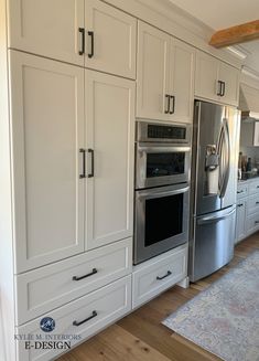 a large kitchen with white cabinets and stainless steel appliances in the center, along with an area rug on the floor